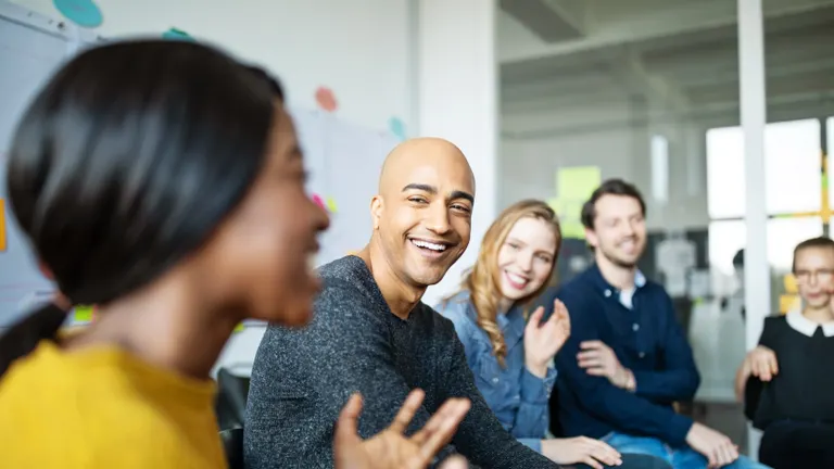 Céges találkozón vidáman beszélgetnek a kollégák