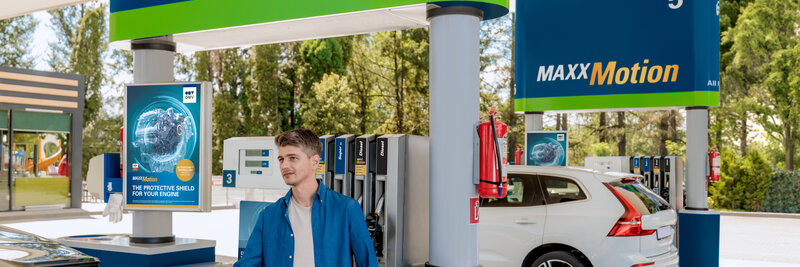 Kék inges férfi OMV üzemanyagot tankol