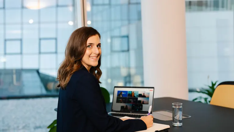 Irodai dolgozó mosolyogva végzi a  munkáját